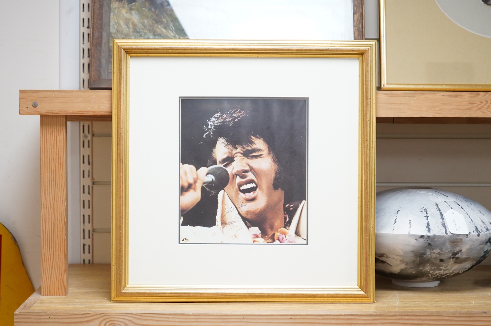 A framed signed photograph of Elvis Presley from his Hawaii show, signed; ‘Best Wishes, Elvis Presley’, originally retailed by Fraser’s, with a certificate of authenticity to the reverse, sold without further provenance,